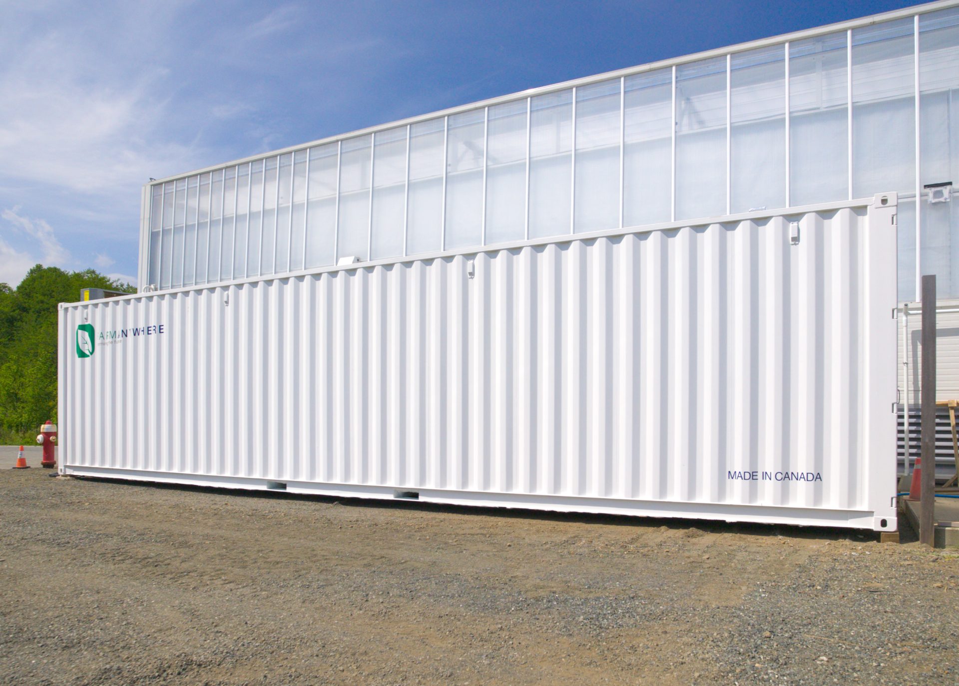 Container farm in front of greenshouse
